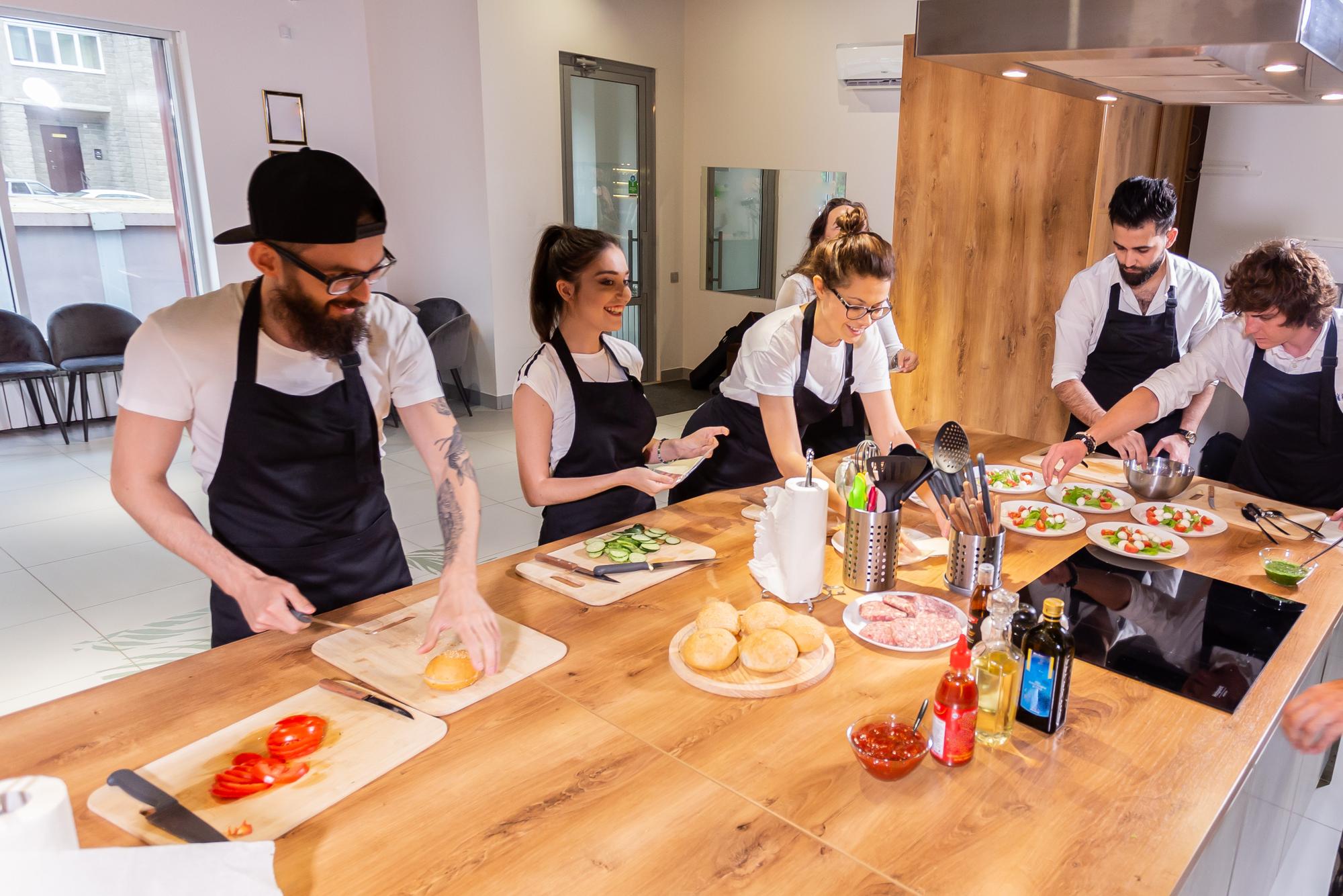 Workshop chef guiding team around a counter